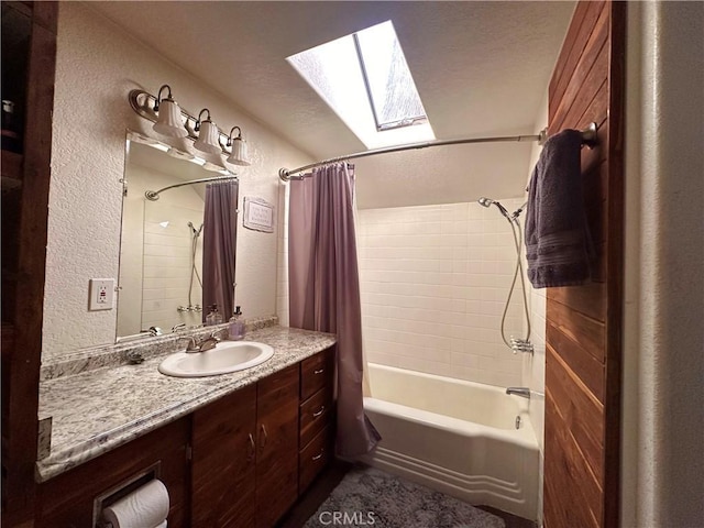 full bathroom with a skylight, shower / bath combo, vanity, and a textured wall