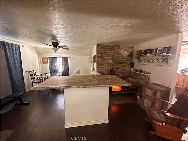 kitchen with dark wood-style floors, a kitchen breakfast bar, and a ceiling fan