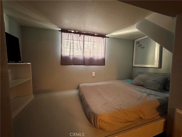 bedroom featuring a textured ceiling and a textured wall