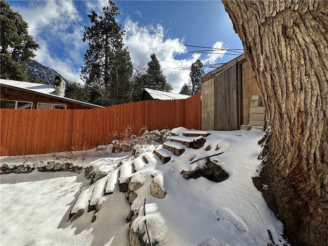 snowy yard featuring fence