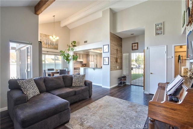 living area featuring a wealth of natural light, beamed ceiling, high vaulted ceiling, and an inviting chandelier