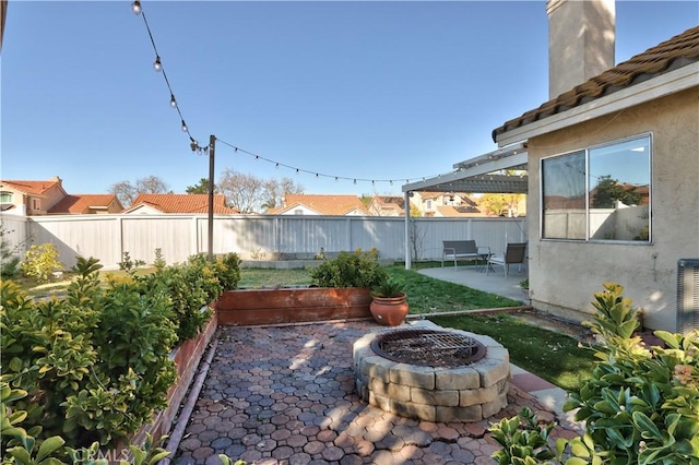 view of yard featuring a patio, fence, and an outdoor fire pit