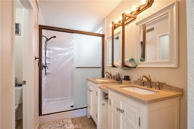 bathroom featuring a sink, visible vents, a stall shower, and double vanity