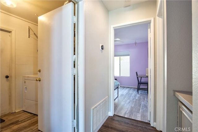 hallway featuring visible vents and dark wood-style flooring