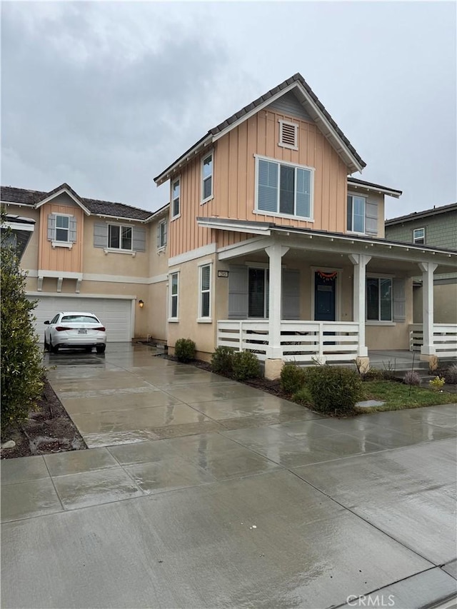 view of front facade featuring a porch, concrete driveway, board and batten siding, and an attached garage