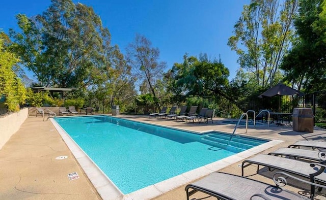 community pool featuring a patio and fence