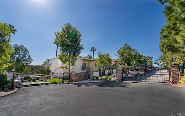 view of front of property featuring covered parking and a gate