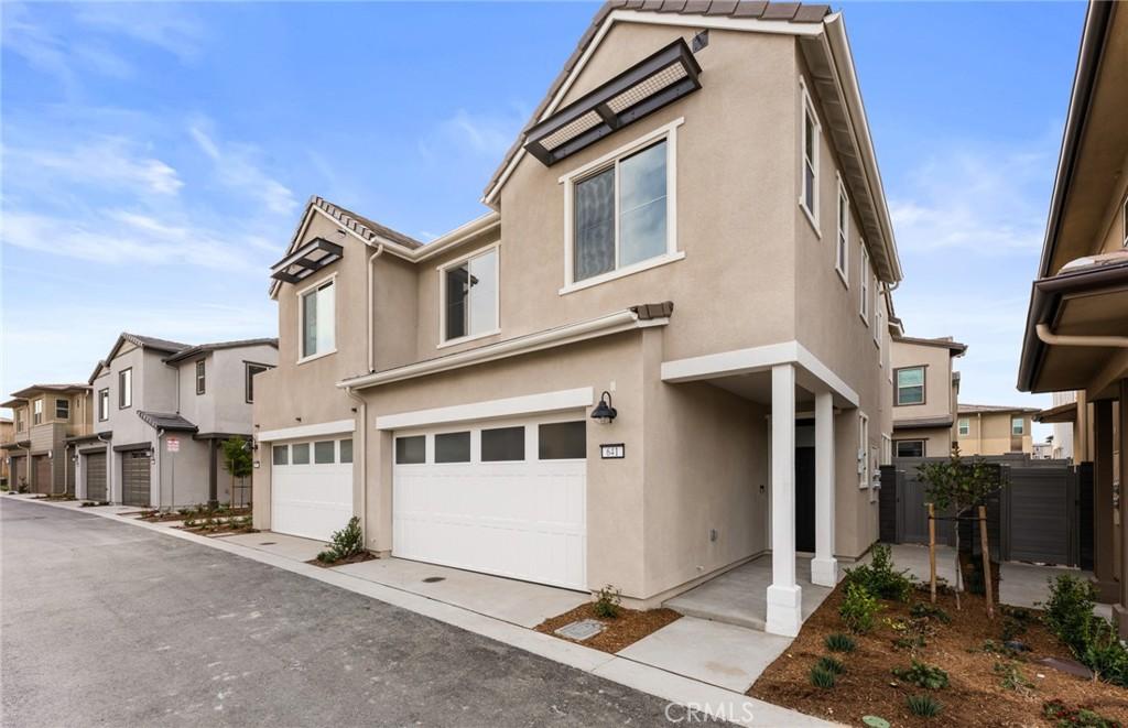 view of front of home with an attached garage, a residential view, and stucco siding