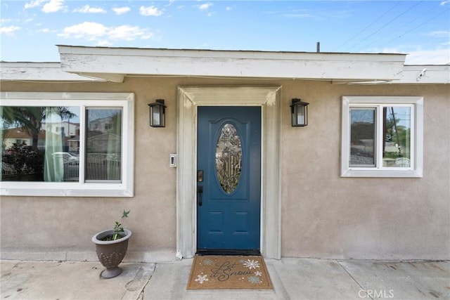 entrance to property featuring stucco siding