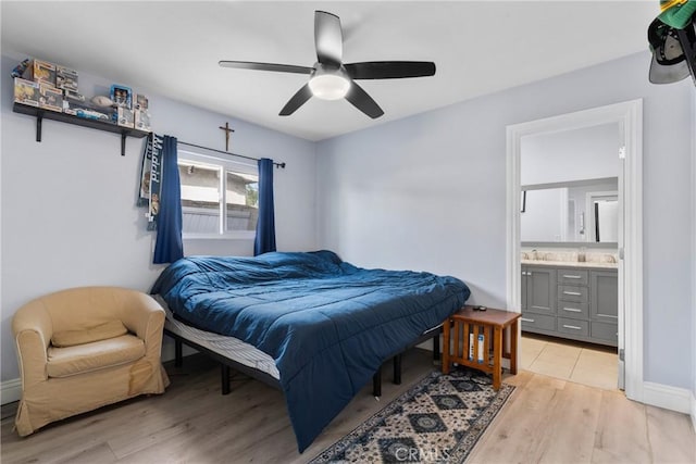 bedroom with a sink, light wood-type flooring, a ceiling fan, and ensuite bathroom