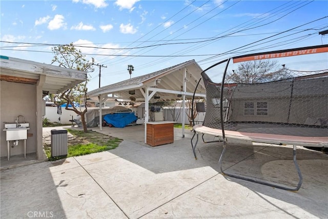 view of patio / terrace with a trampoline and fence