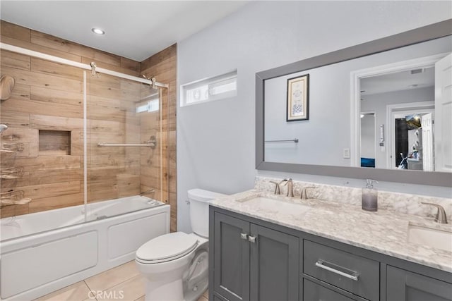 full bath with double vanity, enclosed tub / shower combo, toilet, and a sink