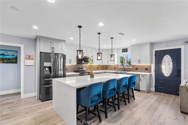 kitchen featuring light wood-style flooring, visible vents, appliances with stainless steel finishes, and a sink