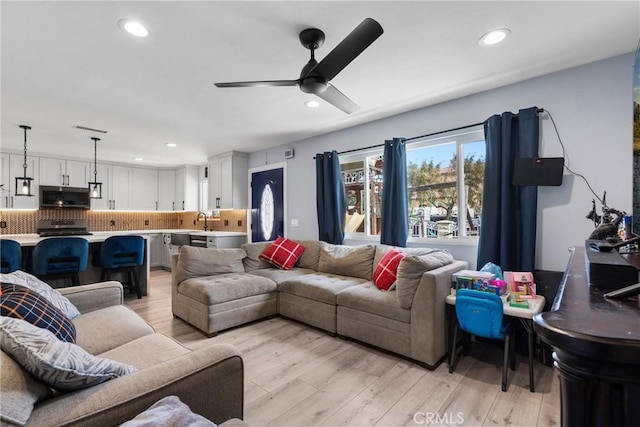 living room with recessed lighting and light wood-style flooring