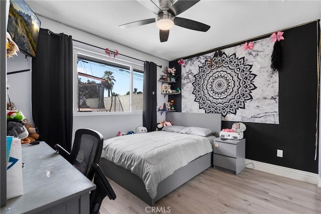 bedroom featuring light wood-style flooring, baseboards, and ceiling fan