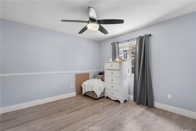 unfurnished bedroom featuring light wood-style floors, baseboards, and ceiling fan