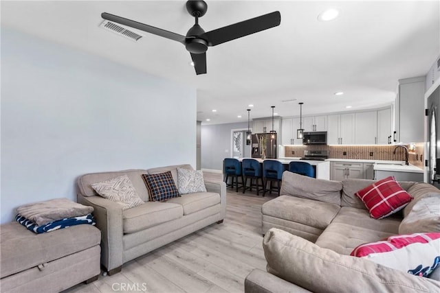 living area featuring recessed lighting, visible vents, and light wood finished floors