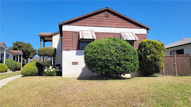 view of property exterior featuring a lawn and fence