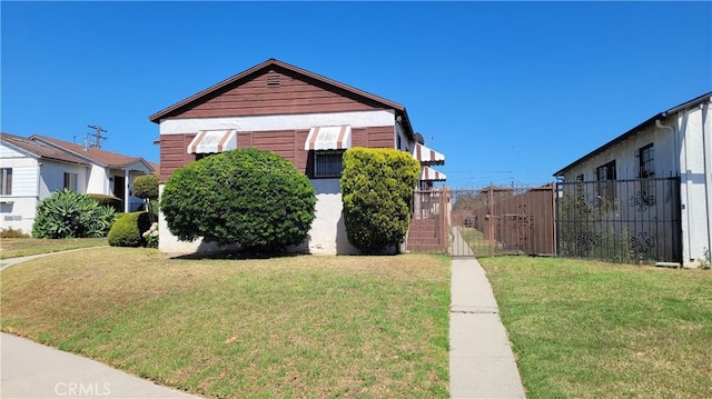 bungalow featuring a front lawn and fence