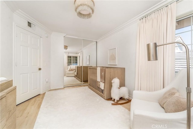 living area with ornamental molding, wood finished floors, and visible vents