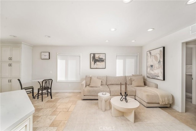 living room with baseboards, stone tile flooring, and recessed lighting