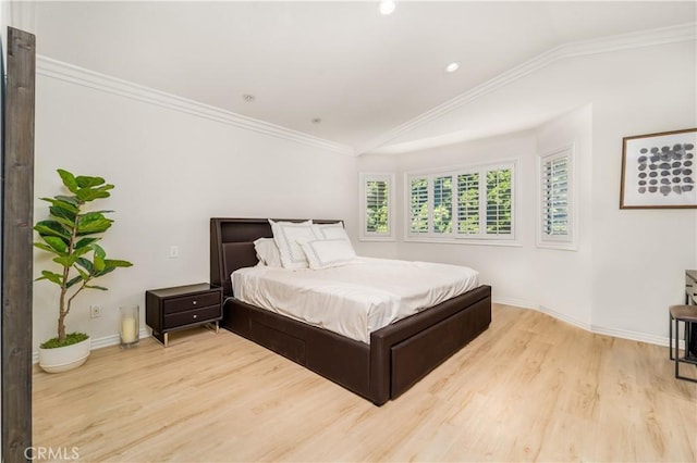 bedroom featuring lofted ceiling, crown molding, baseboards, and light wood-style floors