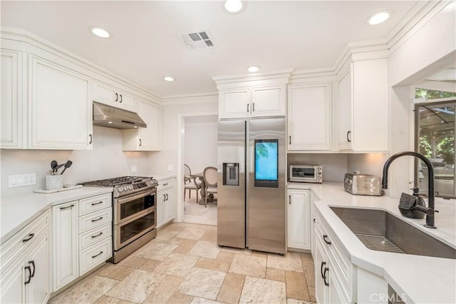 kitchen featuring visible vents, white cabinets, stainless steel appliances, under cabinet range hood, and a sink