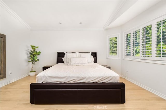 bedroom with baseboards, light wood-style flooring, and crown molding