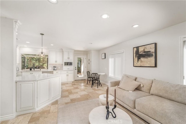 living area featuring recessed lighting, stone finish floor, and baseboards