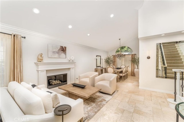 living area featuring stone tile floors, baseboards, a glass covered fireplace, ornamental molding, and recessed lighting