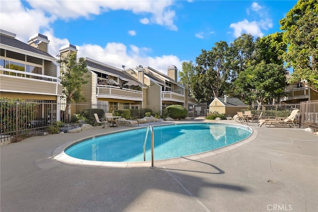 pool with a patio and fence