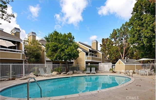 pool with a patio area and fence