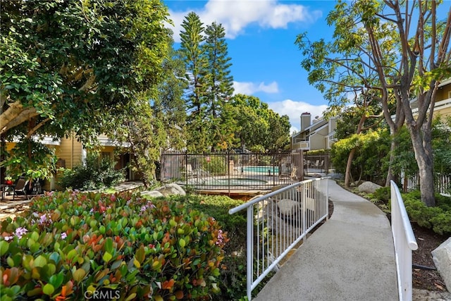 view of home's community featuring fence and a pool