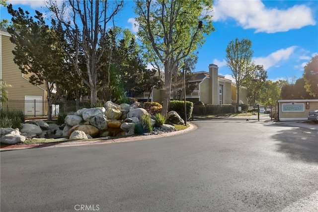 view of road with a gate, curbs, and a gated entry