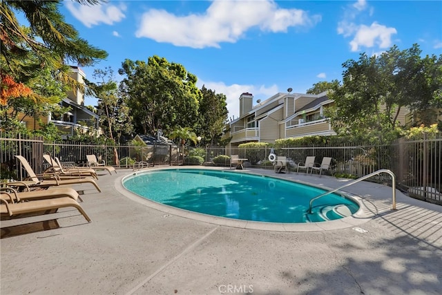 community pool with fence and a patio