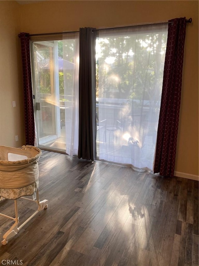 interior space with baseboards and wood finished floors