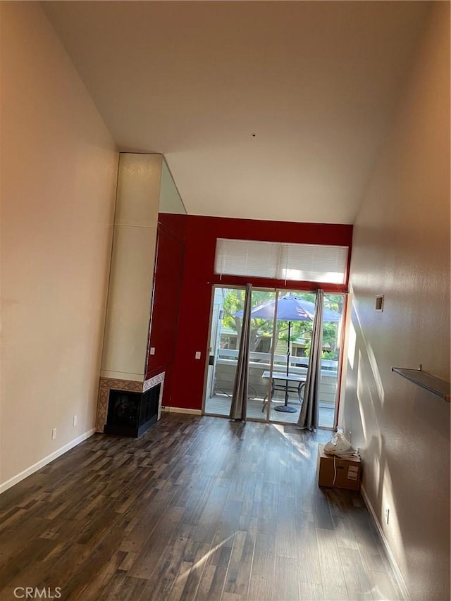 unfurnished living room featuring baseboards and wood finished floors