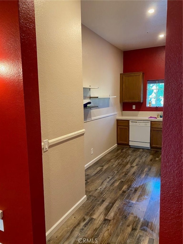 kitchen with baseboards, dark wood-type flooring, dishwasher, and light countertops