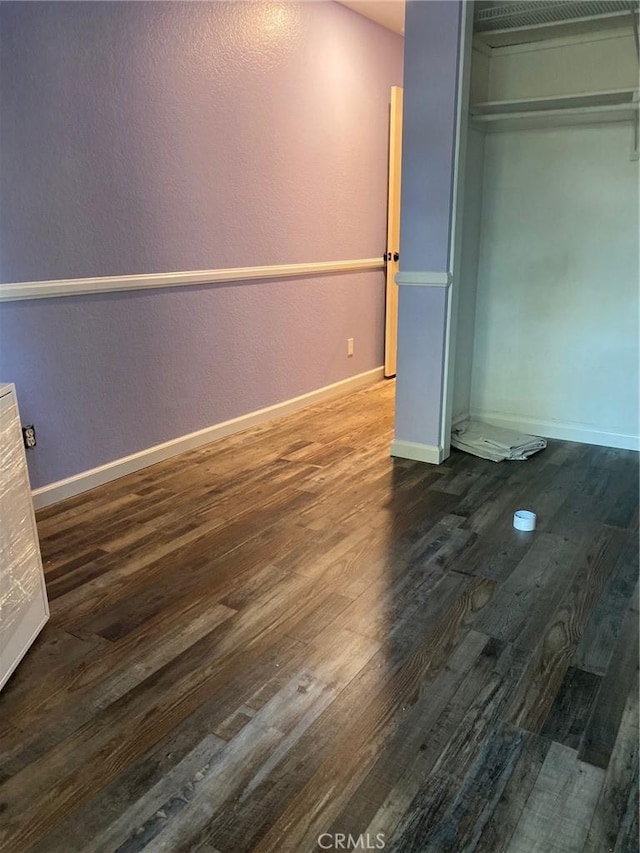 unfurnished bedroom featuring dark wood-style flooring and baseboards