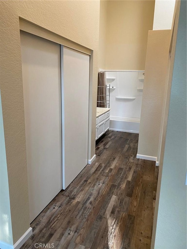 bathroom featuring baseboards, wood finished floors, and vanity