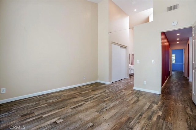 3690 S Bear St Unit 5, Santa Ana, CA 92704 - empty room with dark wood finished floors, recessed lighting, baseboards, a towering ceiling, and visible vents