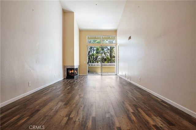 3690 S Bear St Unit 5, Santa Ana, CA 92704 - unfurnished room with a multi sided fireplace, baseboards, and dark wood-type flooring