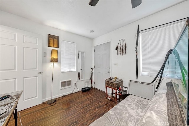 bedroom with ceiling fan, wood finished floors, and visible vents