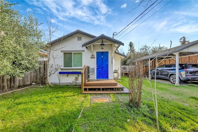 bungalow-style home featuring crawl space, stucco siding, fence, and a front yard