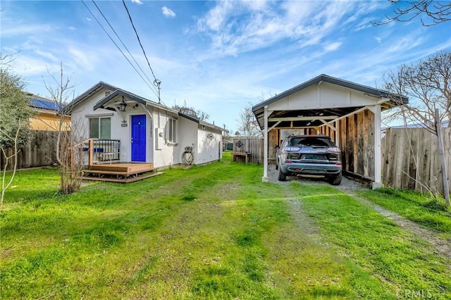 exterior space featuring driveway, fence, and a detached carport