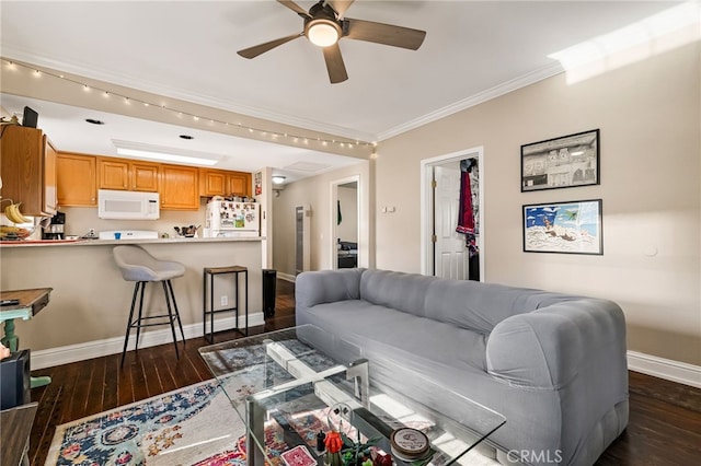 living area featuring dark wood-type flooring, ornamental molding, baseboards, and ceiling fan