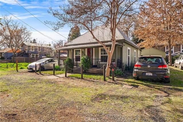 bungalow-style house featuring a porch, a front yard, and fence