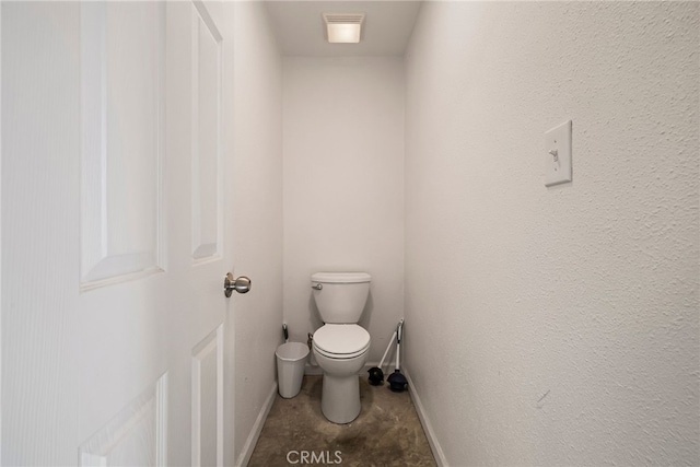 bathroom with toilet, baseboards, visible vents, and a textured wall