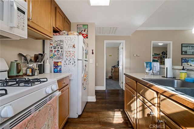 kitchen featuring white appliances, dark wood-type flooring, visible vents, light countertops, and brown cabinetry