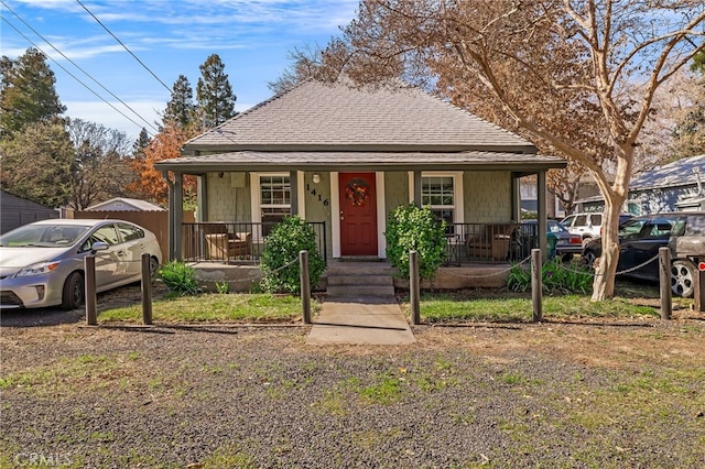 bungalow featuring covered porch and roof with shingles